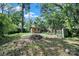 View of a rustic backyard featuring a small shed surrounded by mature trees and natural foliage at 407 Chesterfield Ave, Lancaster, SC 29720