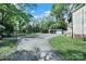 Driveway leading to a large backyard with mature trees, carport, and lounge area at 407 Chesterfield Ave, Lancaster, SC 29720