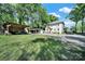Spacious backyard features a covered lounge area, carport, lawn, and mature trees at 407 Chesterfield Ave, Lancaster, SC 29720