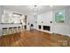 Open-concept living room features a white brick fireplace and adjacent kitchen with barstool seating at 407 Chesterfield Ave, Lancaster, SC 29720