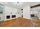 Bright living room with white brick fireplace, wood floors, and an open doorway to another room at 407 Chesterfield Ave, Lancaster, SC 29720