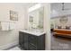 This bathroom features a neutral color palette, a double sink vanity, and an adjacent view of the bedroom at 4412 Foxview Ct, Charlotte, NC 28270