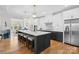 Modern kitchen with large island, white cabinets, stainless steel appliances, and hardwood flooring at 4412 Foxview Ct, Charlotte, NC 28270