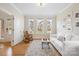 This living room features hardwood floors, a white sofa, and three windows that let in natural light at 4412 Foxview Ct, Charlotte, NC 28270