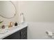 This powder room features gold hardware, a large round mirror, and a solid surface countertop at 4412 Foxview Ct, Charlotte, NC 28270