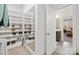 This walk-in closet features built-in shelving, a full length mirror, and a view of the connected bathroom at 4412 Foxview Ct, Charlotte, NC 28270