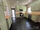 Kitchen features green cabinetry, stainless appliances, and dark wood flooring at 501 E Lafayette St, Salisbury, NC 28144