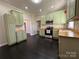 Bright kitchen with green cabinetry, stainless appliances, and a view to the stairs at 501 E Lafayette St, Salisbury, NC 28144