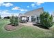 Exterior shot of the house with a patio, dining set, landscaping and a well-maintained lawn at 5039 Folly Ln, Fort Mill, SC 29707