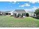 Backyard view featuring patio seating, landscaping, and a large green lawn at 5039 Folly Ln, Fort Mill, SC 29707