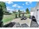 Large backyard with a patio seating area, grill, landscaping, and lush green lawn at 5039 Folly Ln, Fort Mill, SC 29707