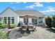 Paved backyard patio with dining set, lounge chairs, an umbrella, and mature landscaping at 5039 Folly Ln, Fort Mill, SC 29707