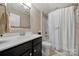 Neutral bathroom featuring a dark vanity, decorative mirror, and a shower with curtain at 5039 Folly Ln, Fort Mill, SC 29707