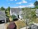 Aerial front exterior featuring lush trees, garden beds and landscaping at 5039 Folly Ln, Fort Mill, SC 29707