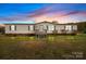 Charming single-story home featuring a well-maintained front yard under a colorful sky at 5110 Old Still Ln, Bessemer City, NC 28016