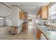 Open kitchen with wood cabinets and appliances, plus a dining area with an adjacent exterior door at 5110 Old Still Ln, Bessemer City, NC 28016