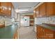Bright, open kitchen features a refrigerator, white appliances, and an adjacent laundry closet at 5110 Old Still Ln, Bessemer City, NC 28016