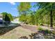 Landscaped backyard features a fire pit, patio with outdoor dining set, and mature trees for shade at 517 Bertram Rd, Fort Mill, SC 29708