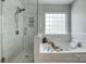 Relaxing bathtub area featuring a glass-enclosed shower and a soaking tub with calming ambiance at 517 Bertram Rd, Fort Mill, SC 29708
