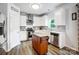 Well-lit kitchen features stainless steel appliances, wooden floors, white cabinets and gray backsplash at 517 Bertram Rd, Fort Mill, SC 29708
