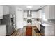 Well-lit kitchen features stainless steel appliances, wooden floors, white cabinets and gray backsplash at 517 Bertram Rd, Fort Mill, SC 29708