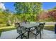Outdoor dining area has an elegant table and seating in the backyard with mature trees offering shade at 517 Bertram Rd, Fort Mill, SC 29708
