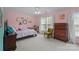 Charming bedroom featuring pink walls, bright natural light, and a white ceiling fan at 5216 Berkeley View Cir, Charlotte, NC 28277