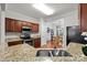 Kitchen showcasing granite countertops, wood cabinetry, stainless appliances, and an adjacent dining area at 5216 Berkeley View Cir, Charlotte, NC 28277