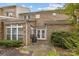 Brick two-story home featuring white French doors and large windows on an outdoor patio at 5216 Berkeley View Cir, Charlotte, NC 28277