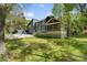 Spacious backyard featuring a lush lawn, stone patio, screen porch and mature trees at 5416 Woodcreek Dr, Charlotte, NC 28226