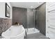 Bathroom features a free standing tub and glass-enclosed shower with gray tiling at 5416 Woodcreek Dr, Charlotte, NC 28226