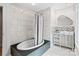Modern bathroom features a soaking tub with gray tile, and unique mirror and vanity cabinet at 5416 Woodcreek Dr, Charlotte, NC 28226