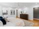 Spacious bedroom with hardwood floors, neutral decor, and an en-suite bathroom, dresser and decor at 5416 Woodcreek Dr, Charlotte, NC 28226