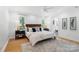 Bright bedroom with hardwood floors, a plush rug, two side tables and a view to the bath at 5416 Woodcreek Dr, Charlotte, NC 28226