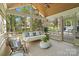 Relaxing screened-in sunroom featuring a hanging swing bed and views of lush greenery at 5416 Woodcreek Dr, Charlotte, NC 28226