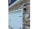 A two car garage featuring stone accents and a carriage door with an address marker at 5711 Skinny Dr, Charlotte, NC 28215