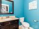 Bright half bathroom with blue walls, stylish vanity with a beige countertop, and modern fixtures at 6013 Coaching Inn Ct, Charlotte, NC 28270
