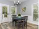 Cozy dining area with backyard access, next to a window, features a black table, chairs and a modern chandelier at 6013 Coaching Inn Ct, Charlotte, NC 28270