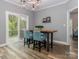 Dining area showcasing a modern light fixture, wood floors, and sliding glass doors leading to an outdoor patio at 6013 Coaching Inn Ct, Charlotte, NC 28270