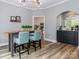Bright dining area features modern light fixture, light wood floors, and connects to an open kitchen at 6013 Coaching Inn Ct, Charlotte, NC 28270
