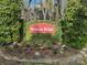 Community entrance sign with flower beds, lush greenery, and stone border at 6013 Coaching Inn Ct, Charlotte, NC 28270