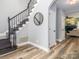 Foyer with attractive wood-look flooring, a staircase with black rails, and neutral gray walls at 6013 Coaching Inn Ct, Charlotte, NC 28270