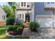 Charming home featuring a landscaped garden and a classic front door with sidelight and second-floor balcony at 6013 Coaching Inn Ct, Charlotte, NC 28270