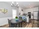 Bright kitchen with stainless steel appliances, granite countertops, white cabinets, wood floors, and breakfast nook at 6013 Coaching Inn Ct, Charlotte, NC 28270
