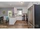Bright kitchen with stainless steel appliances, granite countertops, white cabinets, wood floors and eat-in bar at 6013 Coaching Inn Ct, Charlotte, NC 28270