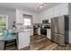 Bright kitchen with stainless steel appliances, granite countertops, white cabinets, and wood floors at 6013 Coaching Inn Ct, Charlotte, NC 28270