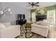 Cozy living room with a fireplace, large windows, comfortable seating, and a ceiling fan at 6013 Coaching Inn Ct, Charlotte, NC 28270