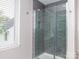 Modern shower boasts glass doors, grey tiling, and a window for natural light at 6013 Coaching Inn Ct, Charlotte, NC 28270