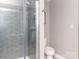 Contemporary shower features glass doors, grey tiles, and convenient shelving at 6013 Coaching Inn Ct, Charlotte, NC 28270