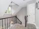 Bright staircase features modern railing, natural light from the window, and neutral paint at 6013 Coaching Inn Ct, Charlotte, NC 28270